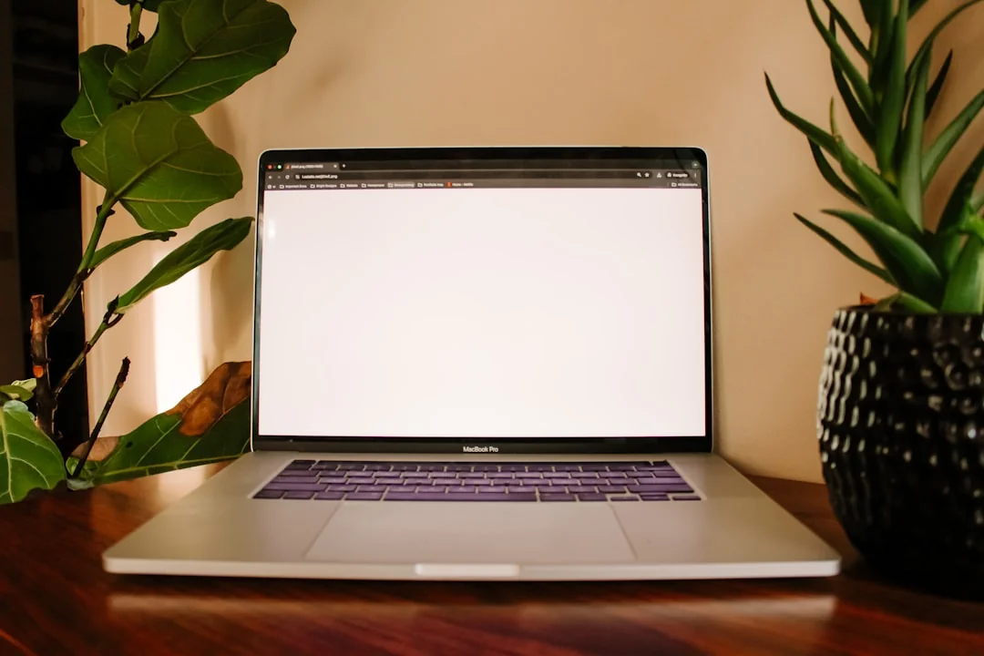 A vibrant workspace featuring a laptop, tablet, and TV with colorful lighting.